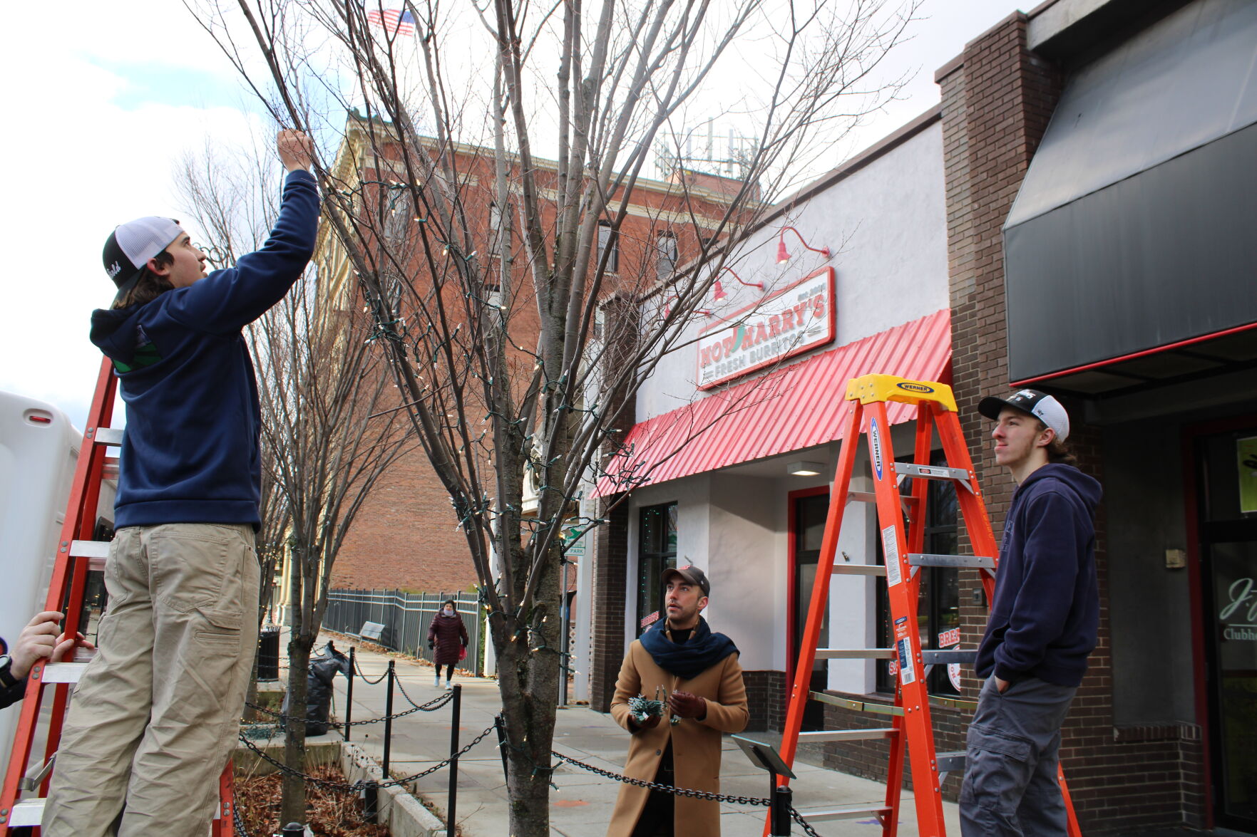 Kavey and Farina look on as Donald Tanner strings lights on North Street